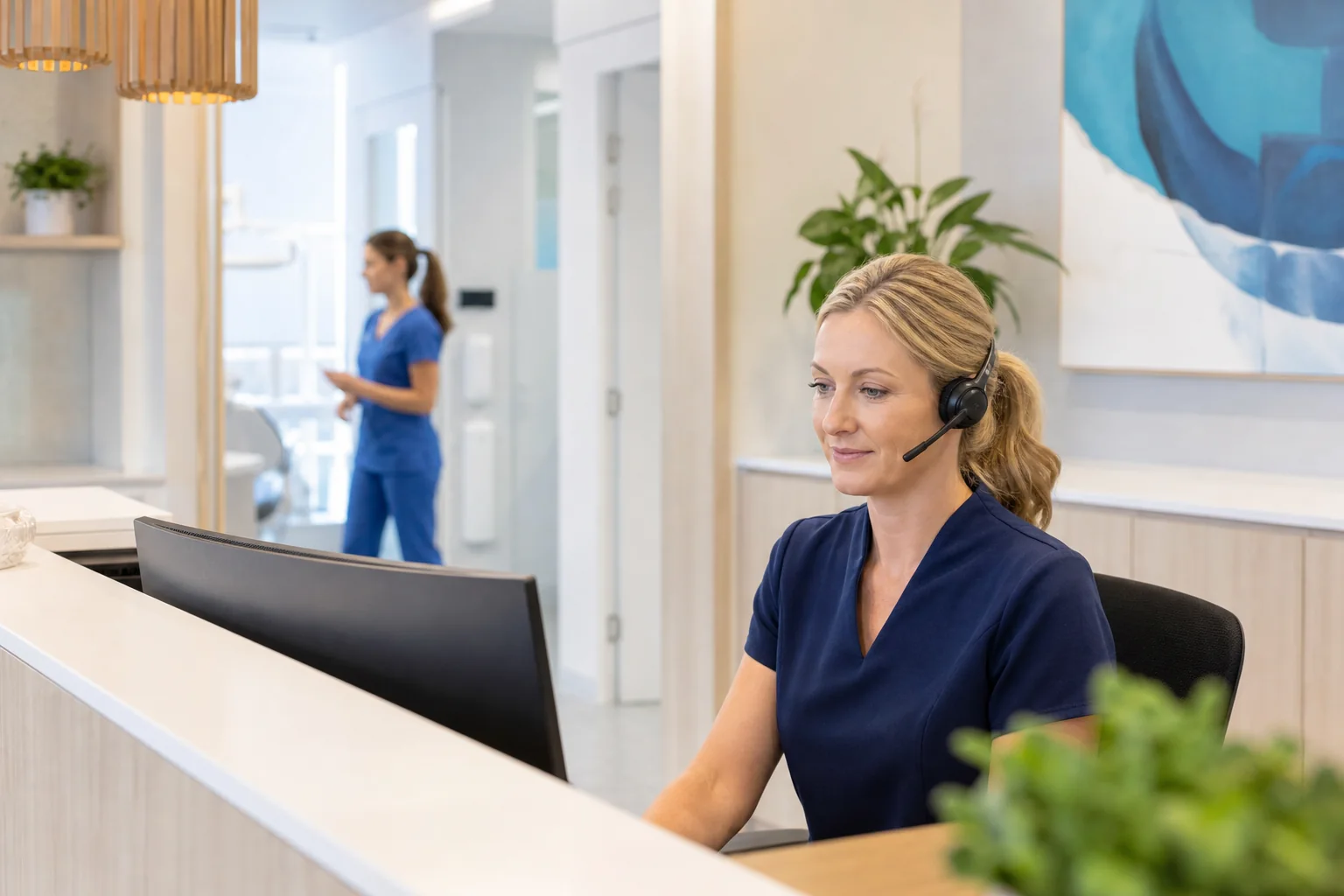 Dental clinic receptionist handling a call at the front desk
